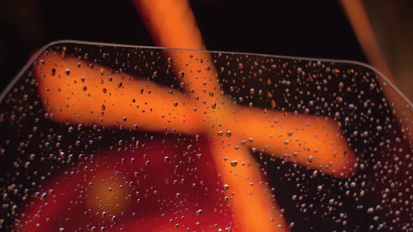 Illuminated Moulin Rough, view through wet car window in night Paris