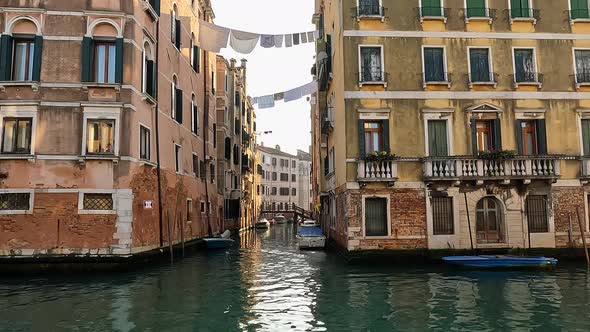 Handheld shot of houses with hanging clothes in Venice, Italy. Slow motion