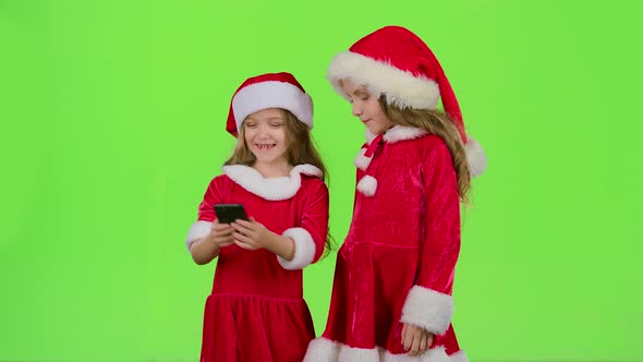 Two Children in New Year Costumes Do Selfie on the Phone. Green Screen. Slow Motion
