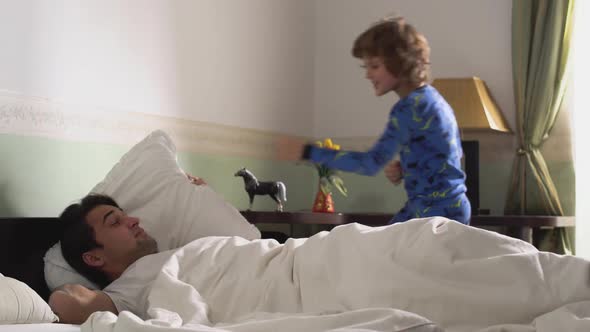 Younger Brother in Pajamas Fooling Around Dancing and Jumping in Front of the Bed 