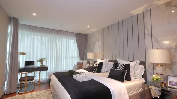 Bedroom furnished with the stylish bedding, couch and lighting furnitures