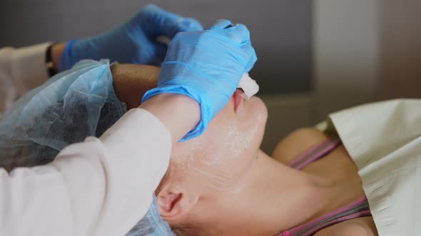 Woman Face Cosmetologist Removing Facial Mask Off