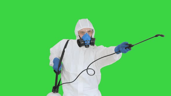 Man Wearing an NBC Personal Protective Equipment Spray Disinfectant and Dancing on a Green Screen