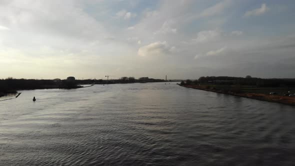 Vessel loaded with multiple containers sailing on the dutch river Oude Maas on a cloudy day. Drone t