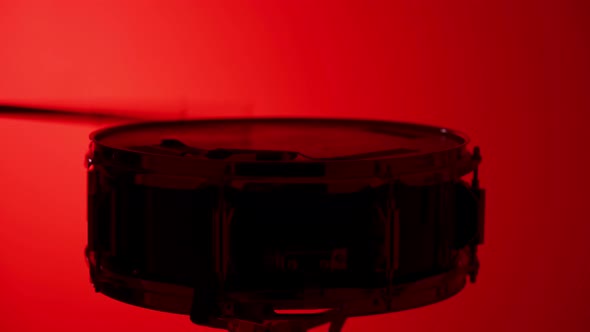 Silhouette Of Drummer Playing On Snare Drum With Sticks On Red Background