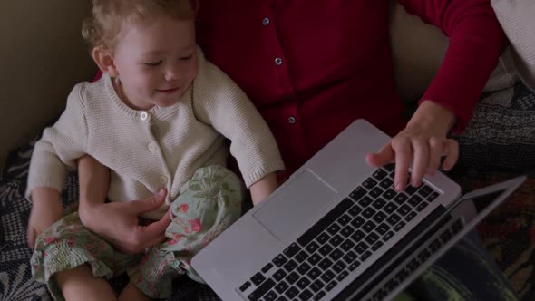 Caucasian woman with baby on laptop at home