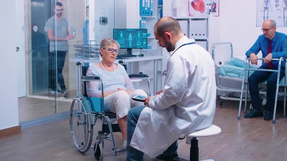 Doctor with Digital Tablet Giving Medical Advice in Recovery Clinic