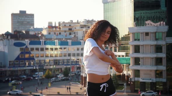 Attractive  Young Woman with Curly Hair Dancing on High Heels on the Roof
