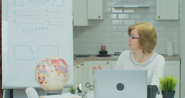 Senior Female Math Teacher Giving Online Lesson on Laptop
