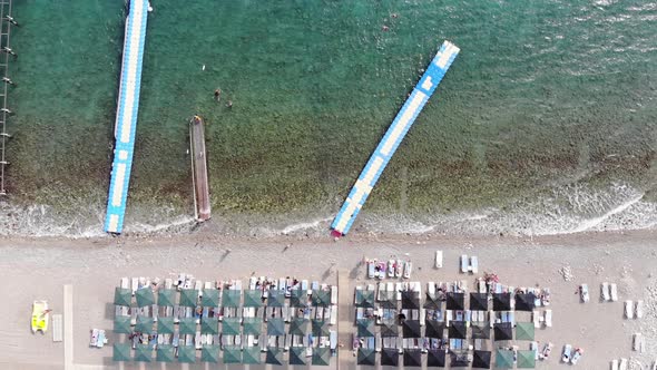 Top View of Plastic Modular Pontoons in Blue Clear Sea and Tourists Having a Rest on a White Beach