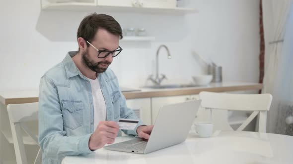 Beard Young Man Celebrating Successful Online Payment on Laptop
