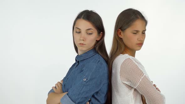 Two Female Friends Standing Back To Back Looking Angry After Having a Fight