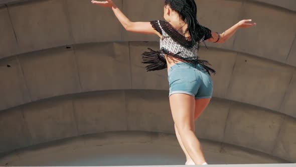 Dancing Female. happy mixed race woman dancing performance with long dreadlocks in shorts