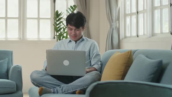 Man Sitting Sofa And Use Laptop Computer In Living Room