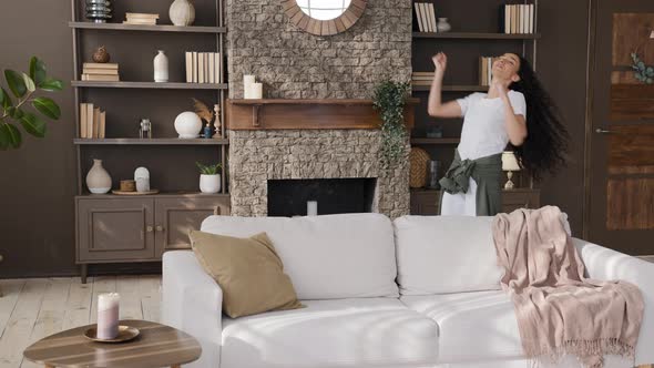 Young Happy Hispanic Woman Enjoying Weekend at Home Actively Moving Dynamic Dancing to Favorite