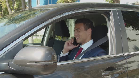 African American Businessman Talks on Phone in Car