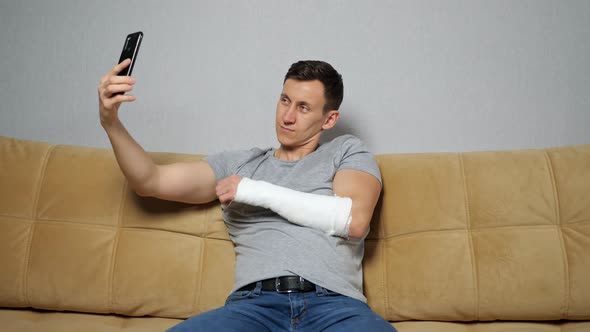 Young Man Makes Selfies Showing Broken Forearm and Posing