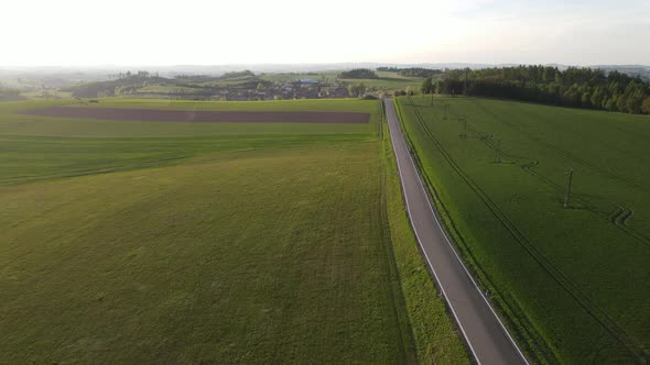 Drone view of road and field near village. Sunset scenic road in Czech republic