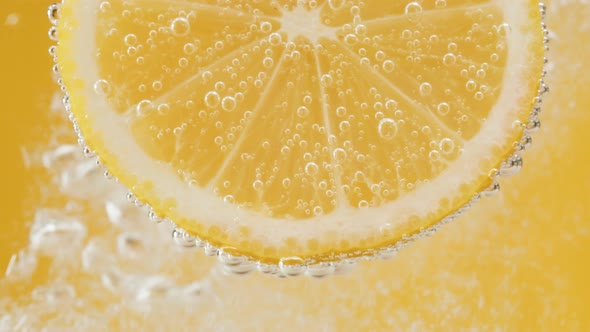 Lemon Slice in Carbonated Water on Yellow Background Fizzy Summer Drink Making Cocktail of Citrus