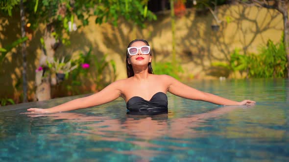 Young asian woman enjoy around outdoor swimming pool for leisure