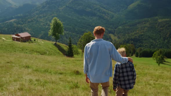 Back View Father Son Walking on Green Hill