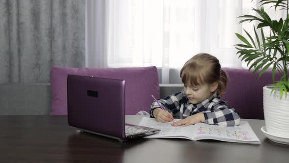 Girl Learning Online Lessons Using Digital Laptop Computer. Distance Education