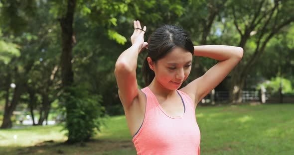 Sport woman stretching arm in park