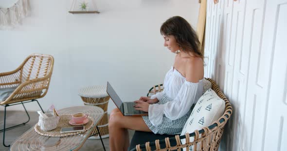 Brunette Woman Working Outsource at Cozy Cafe She Makes Her Presentation on Lap Top Computer