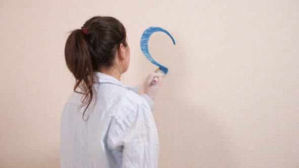 Creative Artist in Shirt Draws Heart with Blue Paint on Wall