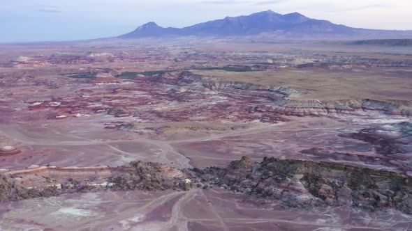 Aerial Scenic Shot Car Crossing Pink Purple Desert Landscape at Dusk Utah