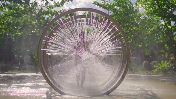 A Young Woman Runs Through a Circular Massage Shower in Aqua Park. Slowmotion Shot