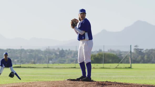 Caucasian female baseball player wearing glasses pitching ball on baseball field