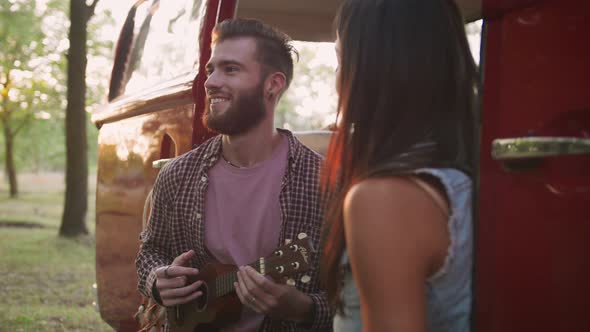 Happy Young Mixed Race Couple Playing Instruments and Having Some Fun in Retro Hippie Minibus in