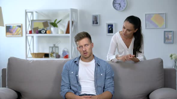 Nervous Woman Criticizing Lazy Husband Sitting on Sofa, Family Conflict, Problem