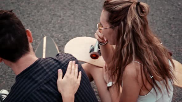 Happy Smiling Teenage Friends Laughing Outside at Something in Smartphone or Mobile Phone