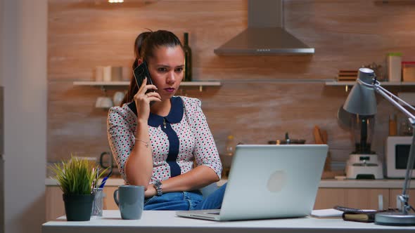 Remote Employee Speaking at Phone While Working
