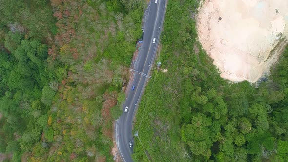 Aerial view of mountain road in forest in autumn season Top view from drone of curve road