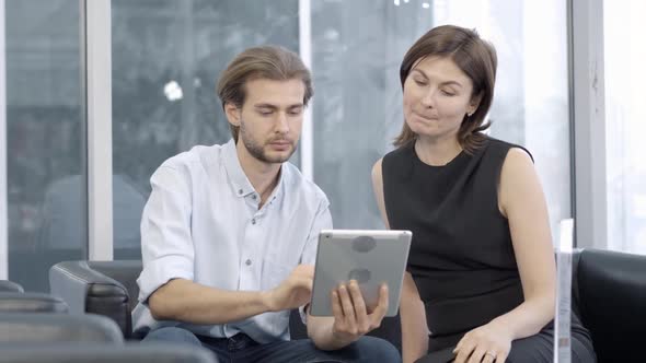 Concentrated Caucasian Man and Woman Using Tablet and Talking, Portrait of Elegant Successful