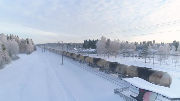 Freight Train Carrying Oil Tankers in Winter Aerial View