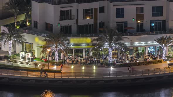 Promenade and Canal in Dubai Marina with Luxury Skyscrapers and Yachts Around Night Timelapse United