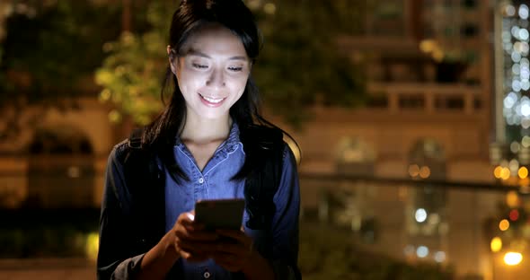 Young woman using smart phone at night 