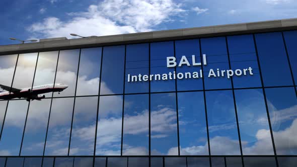 Airplane landing at Bali Indonesia airport mirrored in terminal