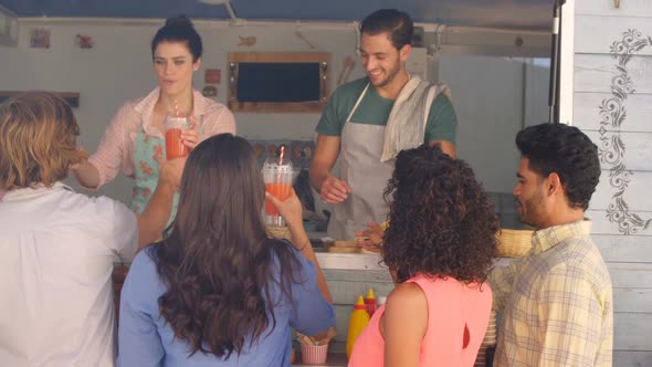 Smiling waiter and waitress taking order from customer