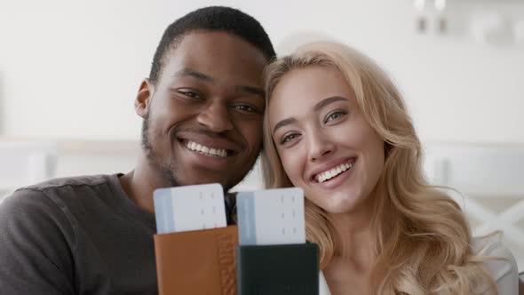 Happy Multiethnic Couple Showing Travel Tickets And Passports Posing Indoors
