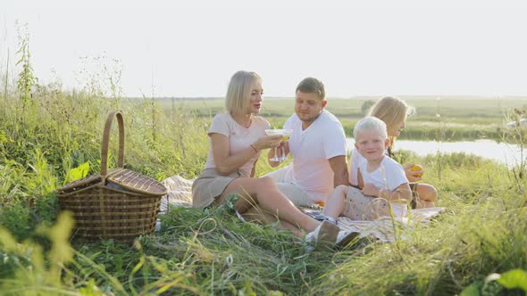 Young Family Having a Picnic By the River