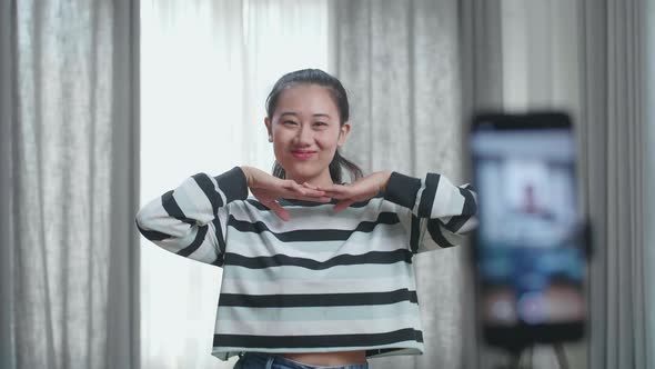 Asian Woman Dancing While Shooting Video Content For Social Networks With A Smartphone Camera