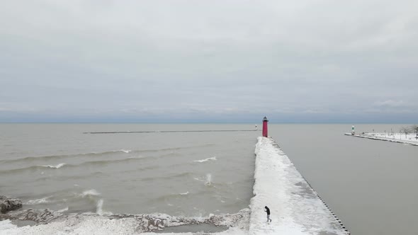 Lake Michigan on a cold, gray winter day with waves crashing against the pier and freezing.