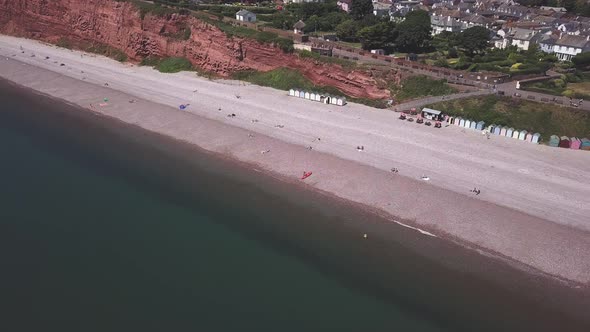 Aerial view of rusty red Triassic cliffs, pebble beach, sea and seafront of Budleigh Salterton. Jura