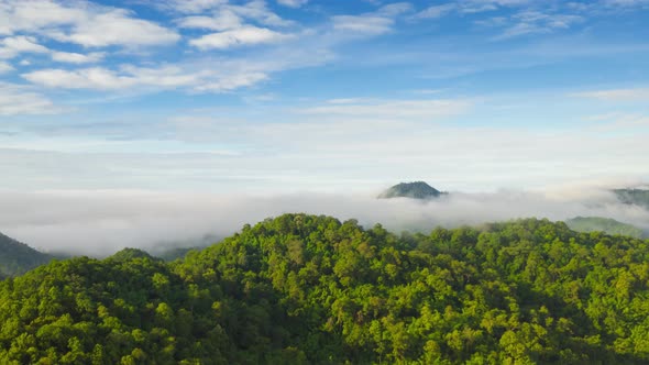 Flying through the clouds above the mountain peak.