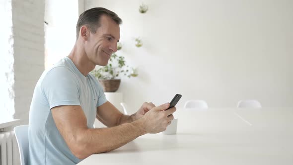 Happy Man Using Smartphone Messaging